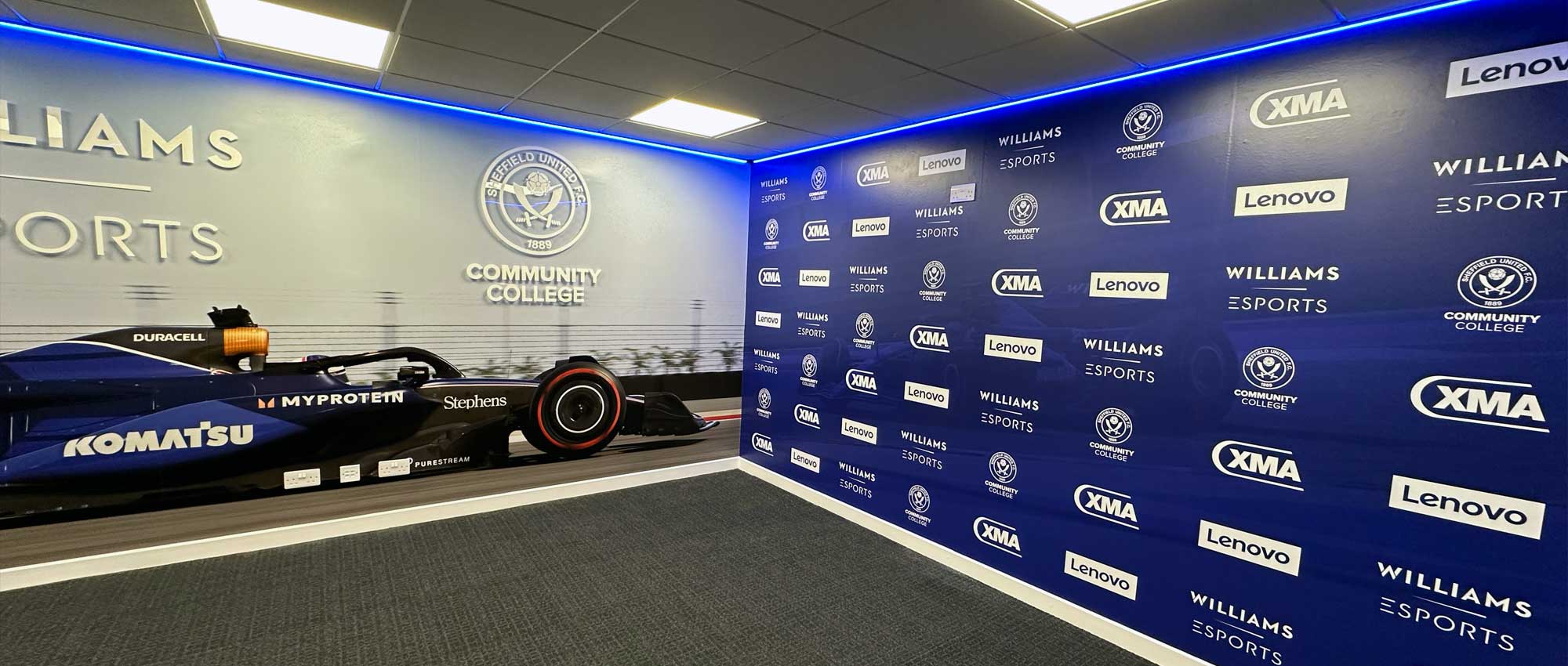 Large format vinyl and acrylic signs designed, printed, and installed for Williams Esports room at Sheffield United Football Club, featuring bold branding graphics and modern esports visuals.